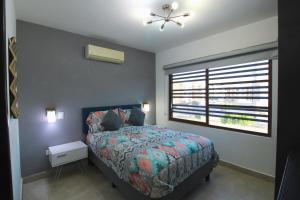 een slaapkamer met een bed en een groot raam bij Departamento Close to Beach - Azul pacifico in Mazatlán +22 foto's