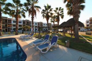 een rij ligstoelen naast een zwembad bij Departamento Close to Beach - Azul pacifico in Mazatlán