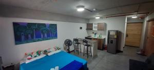 a room with a blue bed and a kitchen at Medellín Apartment Loft in Medellín +11 photos