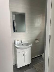 Un baño blanco con lavabo y espejo. en At JayRose, en Kimberley