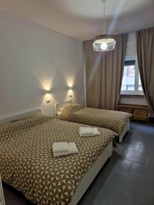 une chambre avec deux lits avec des serviettes blanches dessus dans l'établissement Marchese di Montrone 126, à Bari