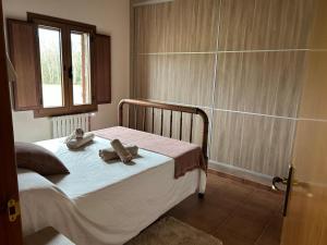 a bedroom with a bed with two towels on it at Can Iglèsies, Vall d'en Bas in Mallol