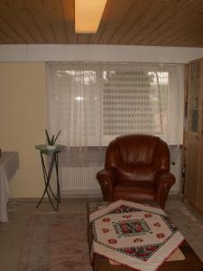 ein Wohnzimmer mit einem braunen Ledersessel und einem Fenster in der Unterkunft Villa Lavendel in Gondiswil