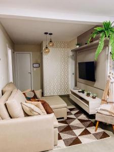 a living room with a couch and a tv at Ap Vista Mar 16 Minutos Beto Carrero Home Office in Piçarras