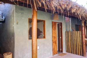 a house with a straw roof and a door at Euodoo in São Miguel dos Milagres