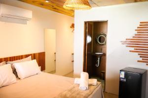 a bedroom with a bed and a bathroom with a sink at Euodoo in São Miguel dos Milagres +2 photos