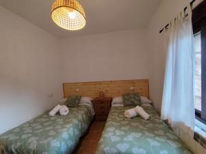 a bedroom with two beds and a window at CR La Carrasca in Riópar