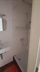 une salle de bain blanche avec une douche et un lavabo dans l'établissement Raunheim, 2 Zimmer Dachgeschoss Apartment, à Raunheim