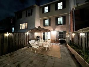 a patio with chairs and an umbrella in front of a house at Cozy Master Room near Washington DC in Annandale +11 photos