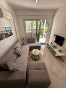 a living room with a couch and a television at Gjiri i Lalzit Lura 3 Apartment Toni in Durrës
