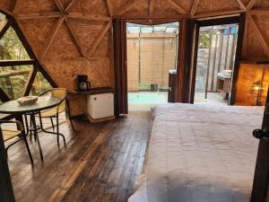 a bedroom with a bed and a table and a tub at Awako Glamping in Moniquirá +15 photos