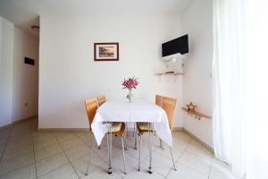 una mesa de comedor con sillas y un jarrón de flores en Apartments Zlatko, en Donje Selo
