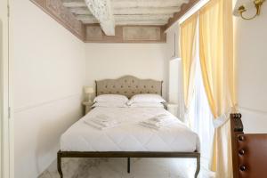 Postel nebo postele na pokoji v ubytování Domus Nannini SPA - L' Arco di Matteotti