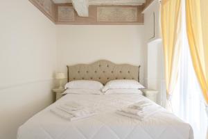 Postel nebo postele na pokoji v ubytování Domus Nannini SPA - L' Arco di Matteotti