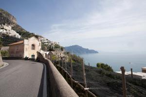 een weg met een kerk op een heuvel naast de oceaan bij A casa di Laura in Amalfi