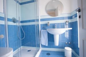 een blauwe betegelde badkamer met een wastafel en een douche bij A casa di Laura in Amalfi +40 foto's