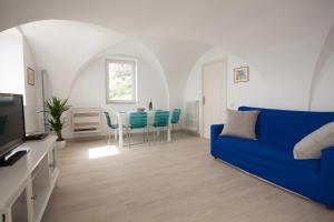 sala de estar con sofá azul y mesa en A casa di Laura, en Amalfi