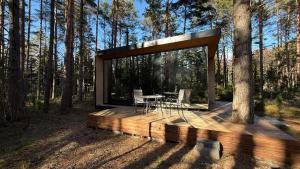 a wooden deck with a table and chairs in the woods at Mooni Minivilla in Haversi