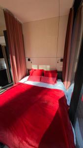 a red bed with red pillows in a bedroom at Mooni Minivilla in Haversi