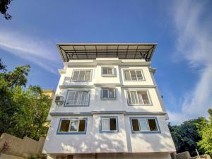 a white building with a roof on top of it at Hotel O Muktesh Chandra in Goa +28 photos
