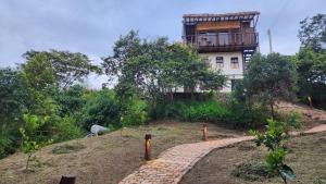 a house on top of a hill with a brick path at Awako Glamping in Moniquirá