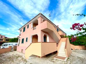 a pink house with stairs in front of it at Sos Alinos - Cala Liberotto - Orosei - Apartment 4 in Cala Liberotto