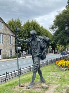 a statue of a man in uniform standing next to a street at PADRÓN PLAZA Lofts, Centro in Padrón +13 photos