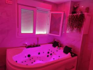 a pink bathroom with a sink and a tub at Apartamento con Jacuzzi El Rincón de las Delicias in Zaragoza +28 photos
