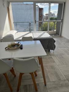 a bedroom with a bed and a table and chairs at Departamento temporal in Morón +12 photos
