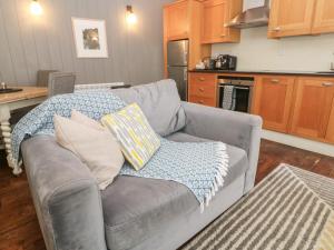 ein Wohnzimmer mit einer grauen Couch mit Kissen darauf in der Unterkunft No 1 The Hinges in Newquay + 10 Fotos