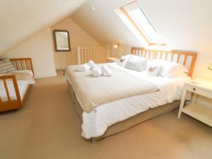 Schlafzimmer im Dachgeschoss mit einem Bett und einem Fenster in der Unterkunft No 1 The Hinges in Newquay