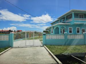 a blue house with a white fence and a gate at Your East Coast Get Away - 43 DougVille in Non-Pariel