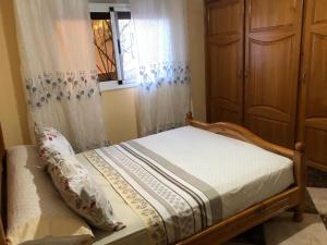 a small bedroom with a bed with a window at Apartamiento con vistas al mar 1 in Tirhanimîne +14 photos