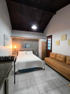 una camera da letto con un letto e un divano di Pousadinha e Residencial Sto António - Praia de Bombas/Bombinhas-SC a Bombinhas