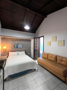 una camera da letto con un letto grande e un divano di Pousadinha e Residencial Sto António - Praia de Bombas/Bombinhas-SC a Bombinhas Altre 156 foto