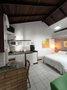 una camera d'albergo con letto, cucina e tavolo di Pousadinha e Residencial Sto António - Praia de Bombas/Bombinhas-SC a Bombinhas