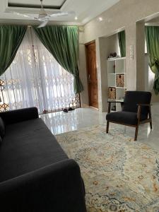 a living room with a couch and a chair at Cozy 2 bedroom apartment in Accra