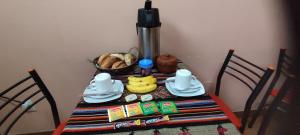 a table with a plate of food and a basket of bread at No Fear Adventure Hostel in La Paz