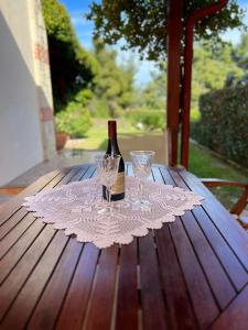 a bottle of wine and two glasses on a table at Little paradise by the sea in Kriopigi