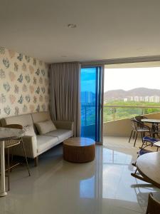 Playa Bello HorizonteU-GO Oasis: Encanto y Confort Frente al Mar en Santa Marta的客厅里有一张沙发和一张桌子。