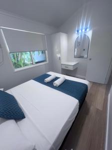 a bedroom with a large white bed and a mirror at Ellis Beach Oceanfront Holiday Park in Palm Cove +99 photos
