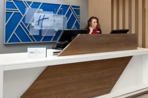 a woman talking on a phone at a desk at Holiday Inn Express Harrisburg I-81 - Hershey By IHG in Manadahill +59 photos