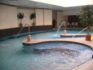 a large swimming pool in a hotel lobby at Palast Wellness Appartement in Hévíz