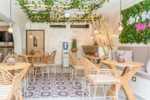 a restaurant with tables and chairs and plants at Casana Rosa Hotel in Santa Marta