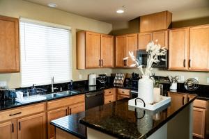 a kitchen with wooden cabinets and a vase of flowers on a counter at Eat-Sleep-Stroll-Repeat! Walkable Midtown 2BR Home in Reno