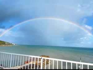 Rat IslandOcean Garden Studio II的海面上有一个彩虹,有白色的栅栏
