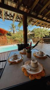 a table with cups and saucers on top of it at Encanto do Mar Pousada in Caraíva