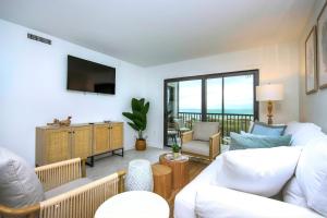 a living room with white furniture and a balcony at Spacious 2BR Condo With Beach Views Sanibel Island 1C2 in Sanibel