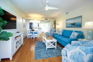 a living room with a blue couch and a table at Beachfront Condo, Sanibel Sandalfoot 1C1 in Sanibel