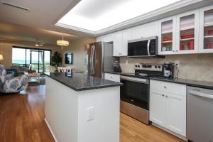a kitchen with white cabinets and a counter top at Beachfront Condo, Sanibel Sandalfoot 1C1 in Sanibel